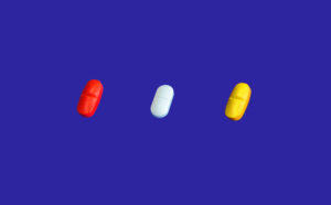 Three different coloured pills.