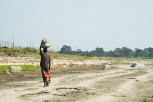 A person carrying a heavy basket of rocks